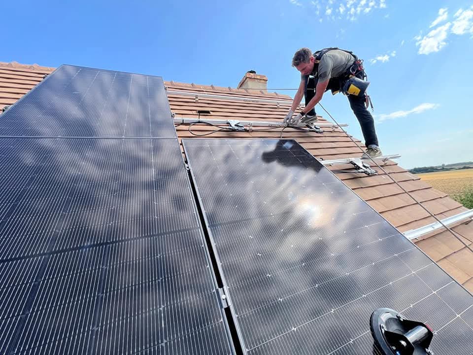 Un couvreur posant des paneaux solaires sur un toit